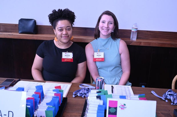 Two people at a check-in table smile for a photo 