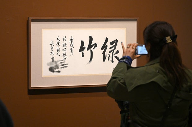 Una mujer mira un pedazo de caligrafía creada por el activista de la independencia coreana Ahn Jung-Geun en su celda de la cárcel semanas antes de su ejecución en 1910, en la subasta de Seúl en Seúl, el 22 de abril de 2025.