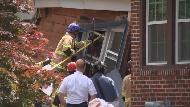 First responders work on the house after the truck crashed into it 