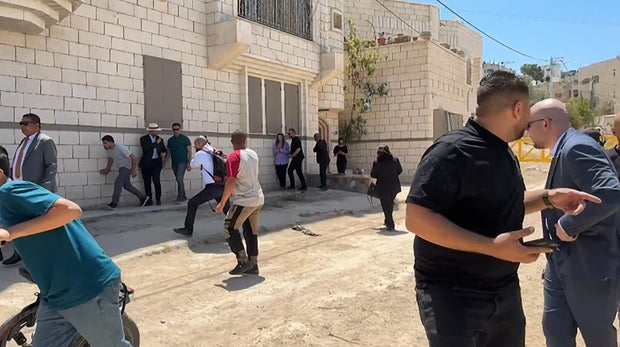 A frame grab from AFPTV video shows members of a diplomatic delegation from the European Union and elsewhere reacting after shots were fired as they gathered at the eastern entrance of the Jenin camp, during a visit to the city of Jenin, in the Israeli-occupied West Bank, May 21, 2025, amid an ongoing Israeli military offensive