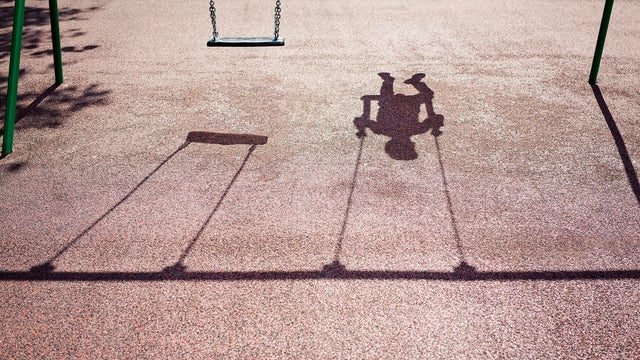 Shadow of a child on a playground swing 