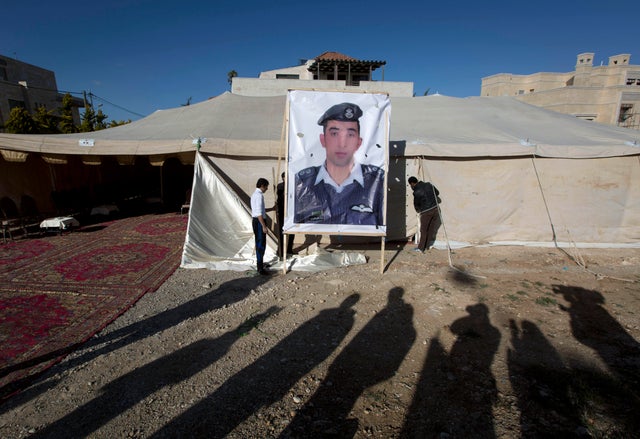 In this Jan. 30, 2015, file photo, workers raise a banner with a photo of Jordanian pilot Lt. Mu'ath al-Kaseasbeh, who was held captive by ISIS, outside a tent for supporters in Amman, Jordan. 