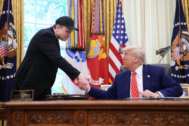 lon Musk shakes hands with President Trump