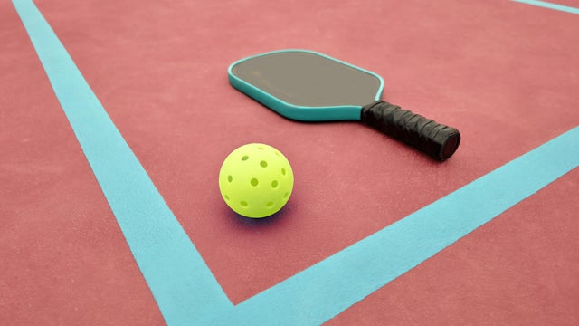 Pickleball Paddle and Ball on Red Pickle Ball Court 