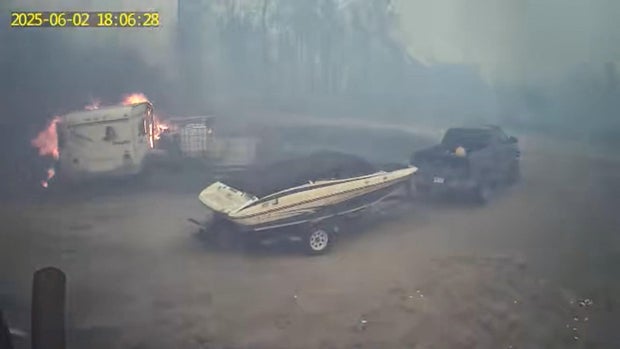 Smoke from a wildfire fills the air as a trailer burns in La Ronge, Saskatchewan