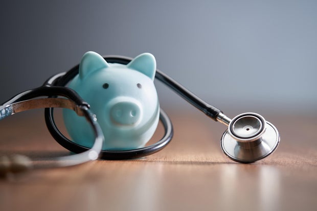 Close-up of piggy bank with stethoscope on table 