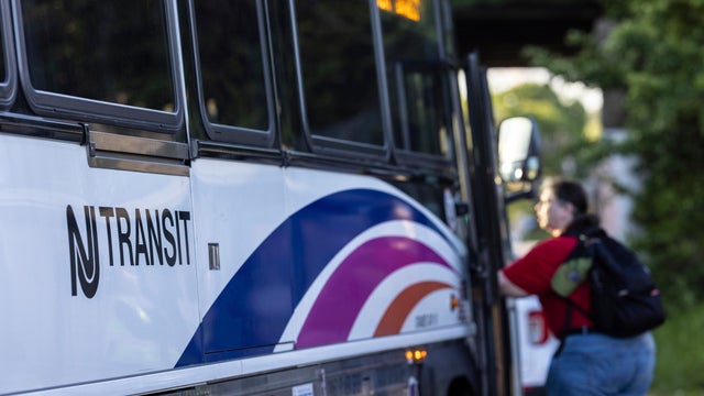 A commuter boards a NJ Transit bus bound for New York City at the Allwood Park and Ride stop in Clifton, N.J. on May 19, 2025. 