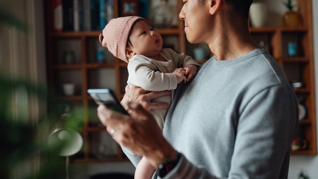 Asian father taking care of his baby while working from home 