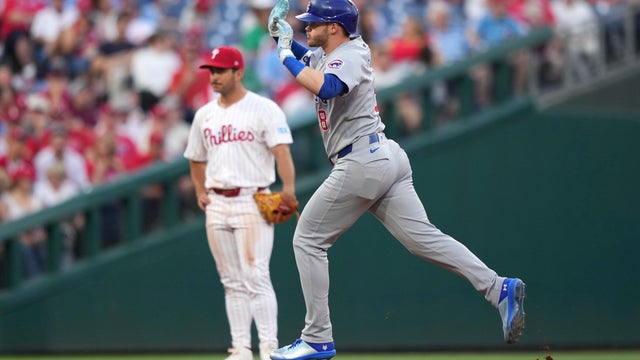 Chicago Cubs' Ian Happ reacts as he runs past Philadelphia Phillies third baseman Otto Kemp after hitting a home run 