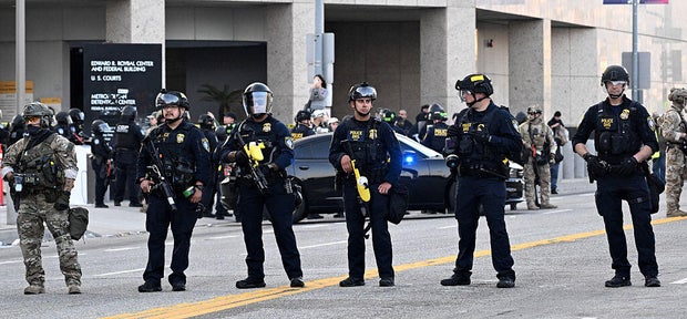 U.S. Border Patrol and Custom officers and U.S. Immigration and Customs Enforcement agents stand guard outside the federal building in Los Angeles on Wednesday, June 11, 2025. 