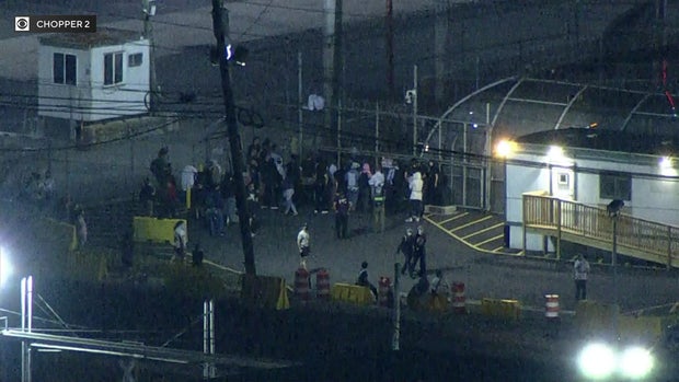 A small crowd of people gathered outside Delaney Hall in Newark, New Jersey, on June 12, 2025. 