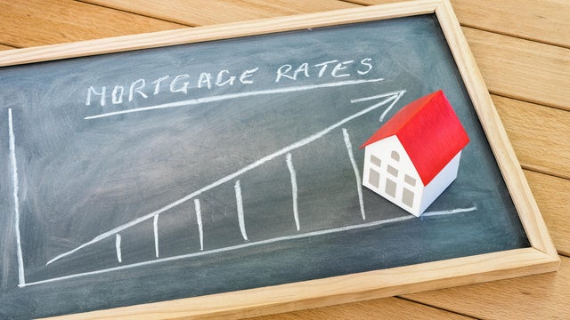 Rising mortgage rate graph on a blackboard lying on a wooden table 