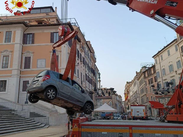 A car that was driven by mistake down the Spanish Steps in Rome on June 17, 2025, is lifted from the landmark in a picture Italian firefighters posted to social media.
