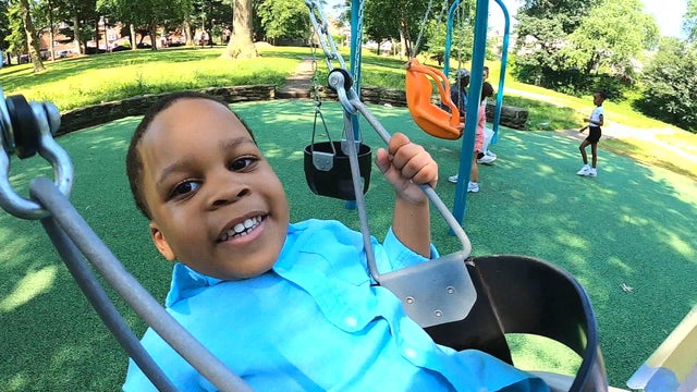 3-year-old Kaliph smiles while he swings at a park in Germantown 