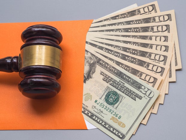 4 signs the IRS may be preparing to garnish your wages money legal Financial business concept wooden gavel with usa dollar close up