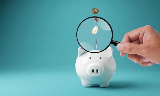Piggy bank with magnifying glass. Money box with falling coins. moneybox investing, 3D rendering 
