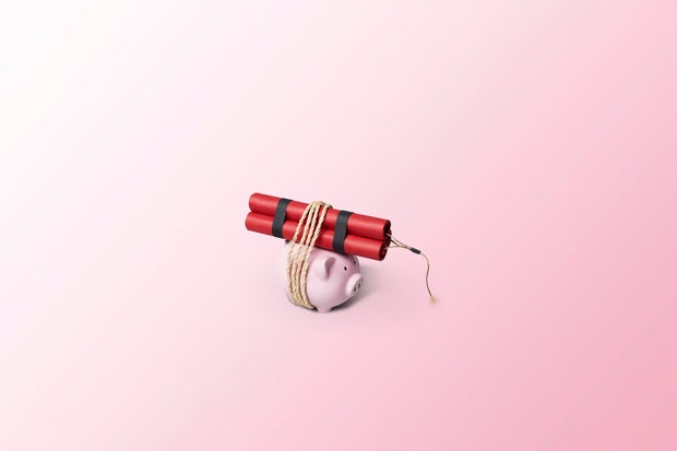 Piggy bank tied to a bundle of dynamite sticks 