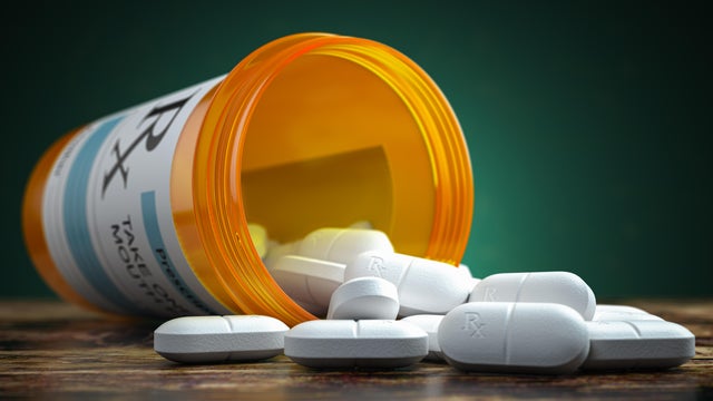 Pills spilling out from yellow container. Medical and pharmaceutical concept. 