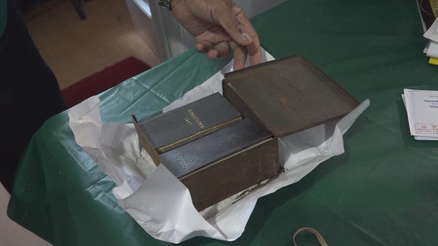 A box contains historic books found at the church, a Bible and a Book of Discipline 