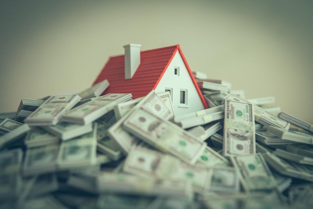 A house drowning in heap US dollar banknotes.