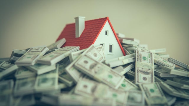 A house drowning in heap US dollar banknotes. 