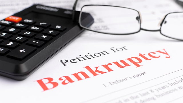 Bankruptcy concept. Close-up bankruptcy petition with calculator and glasses. 