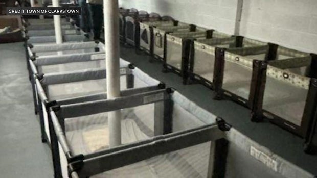 Rows of cribs in an unfinished basement 