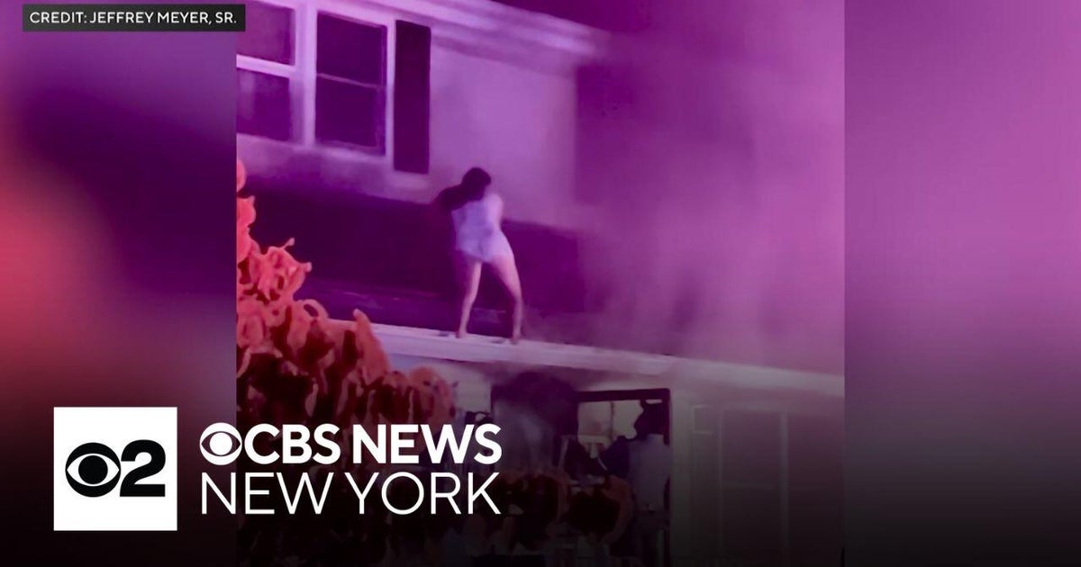 Woman rescued from burning roof after saving people inside - CBS New York