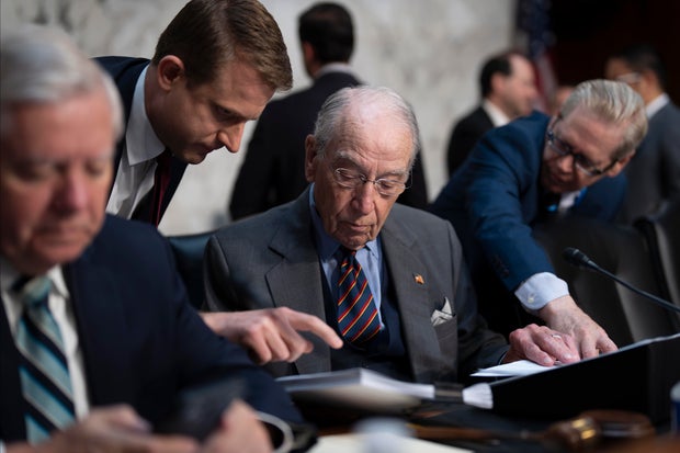 Senate Judiciary Committee Chairman Chuck Grassley confers with aides as the panel meets to advance President Trump's nominees for the federal bench on Thursday, July 17, 2025. 