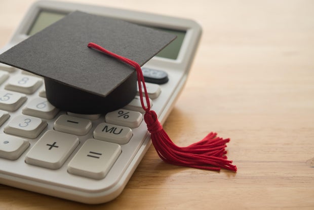 Mortarboard on white calculator. 