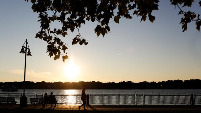 HOLLAND, MI - August 6: People walk along the shore of Lake Mac 