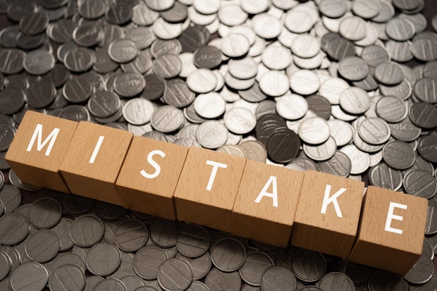 Wooden blocks with "MISTAKE" text of concept and coins. 