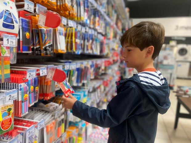 Boy looking for back to school stationery in a store 