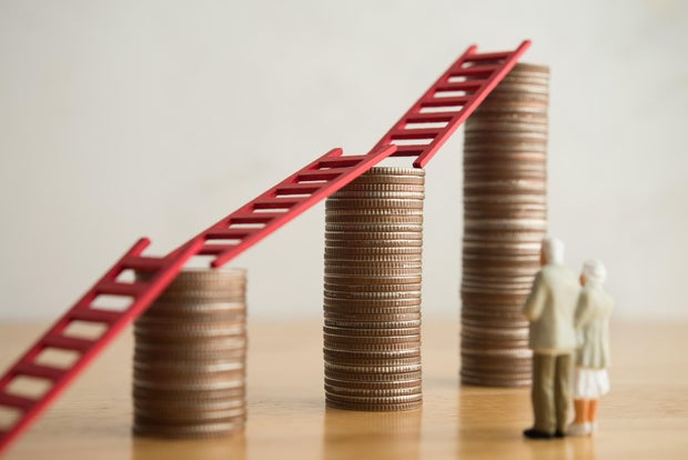 Love old senior couple looking at growth stack coins graph chart with red ladder. 