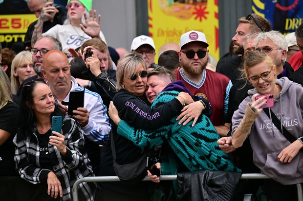 Mourners and music fans line the streets to pay their respects as the funeral cortege of Ozzy Osbourne, the late lead singer of Black Sabbath, makes its way through Birmingham, England, July 30, 2025. 