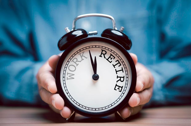 Businessman holding black alarm clock with clockwise countdown from work to retirement. 