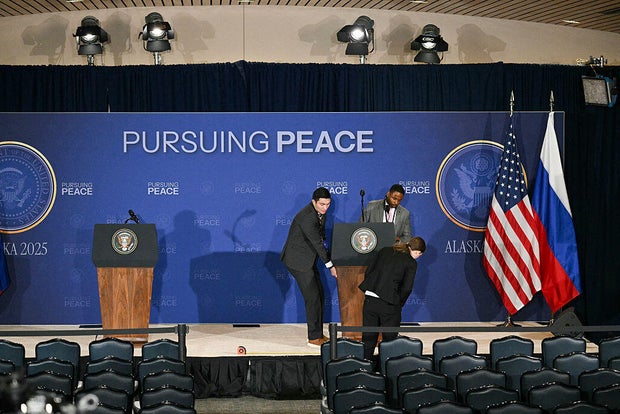 Staff members set up a stage ahead of the summit between President Trump and Russian President Vladimir Putin at Joint Base Elmendorf-Richardson in Anchorage, Alaska, on Aug. 15, 2025. 