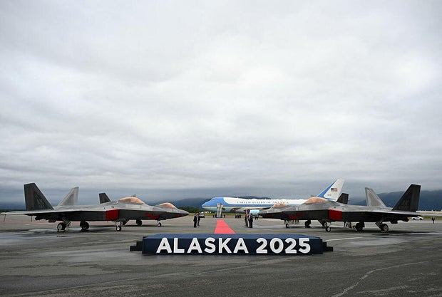 F-22 fighter jets are seen on the tarmac with Air Force One in the distance after President Trump landed at Joint Base Elmendorf-Richardson in Anchorage, Alaska, on August 15, 2025. 