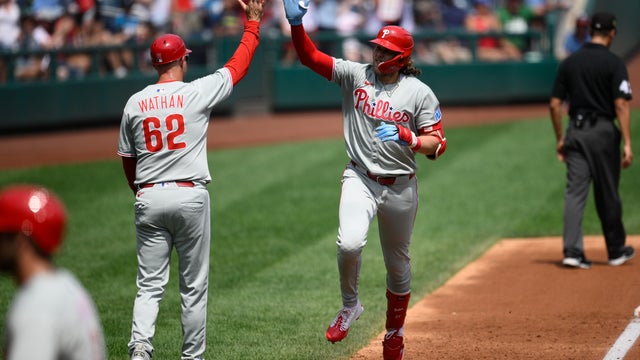 Philadelphia Phillies' Alec Bohm, right, gives a high five to third base coach Dusty Wathan as he rounds the bases after a home run 