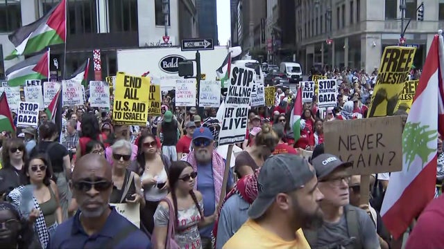 Protesters with signs outside the New York City Public Library 