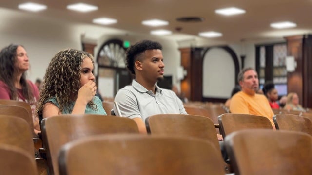 Staff listen during a meeting in an auditorium at Frankford High School 
