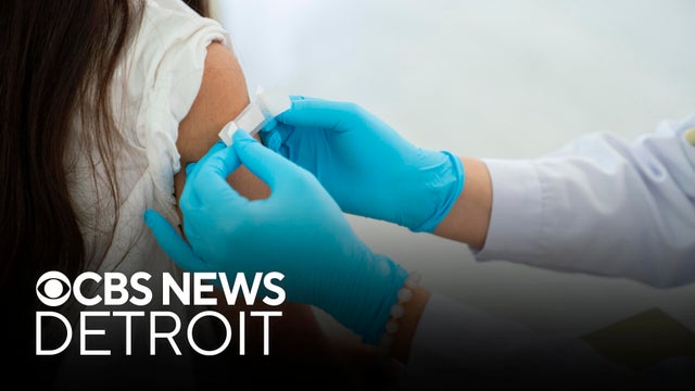 Doctor applies bandage to preteen girl's arm following an immunization 