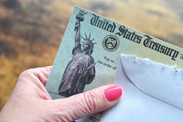 Female holding a check from the United States Treasury 