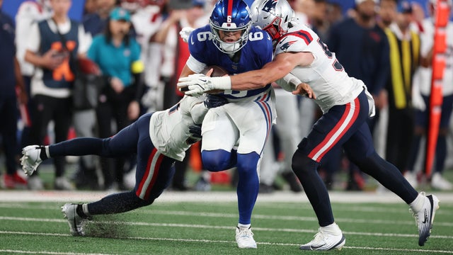Jaxson Dart #6 of the New York Giants loses the ball as he is tackled by Jack Gibbens #51 of the New England Patriots during the first quarter of their NFL Preseason game at MetLife Stadium on August 21, 2025 in East Rutherford, New Jersey. 
