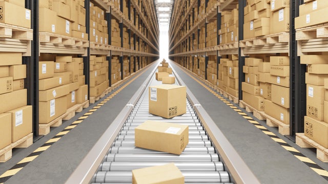Cardboard boxes on conveyor belt in warehouse 