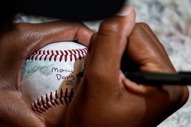 Mo'ne Davis autographs baseballs during the fourth day of tryouts for the Women's Professional Baseball League 