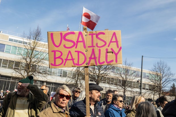 A protester holds a placard saying "U.S.A. IS A BAD ALLY" 