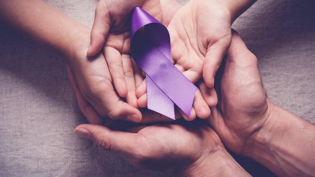 Adult and child hands holding purple ribbons, Alzheimer's disease, Pancreatic cancer, Epilepsy awareness, world cancer day 