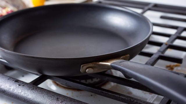 A view of a nonstick skillet pan on a stovetop in a kitchen setting. 