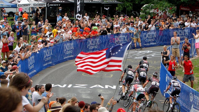 A fan holds up a Betsy Ross American flag as crowds gather to cheer for athletes in the Philly Cycling Classic on Lemon Hill in 2013 